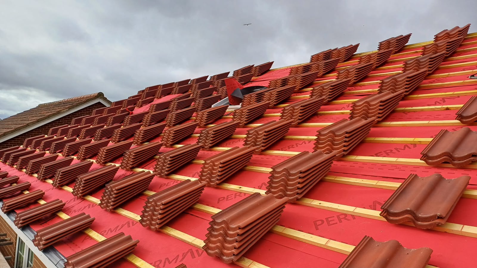 Roofers installing a new slate roof on a build in the North East