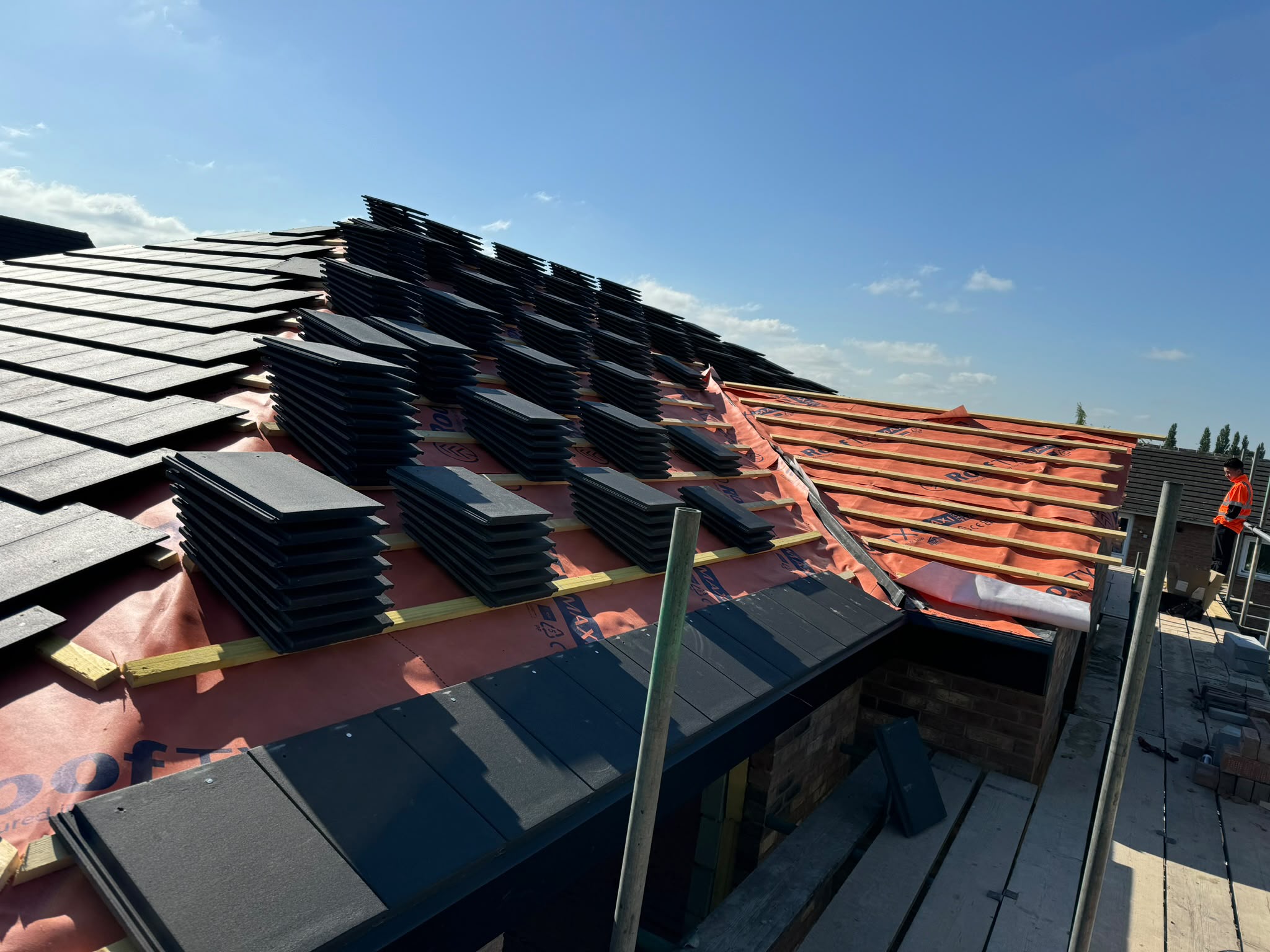 A pitched roof being re-tiled during a full re-roof