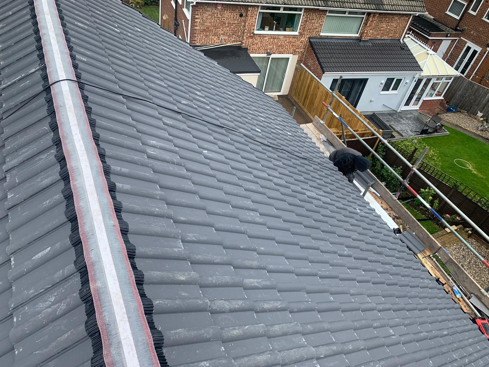New interlocking roof tiles being fitted on a membrane